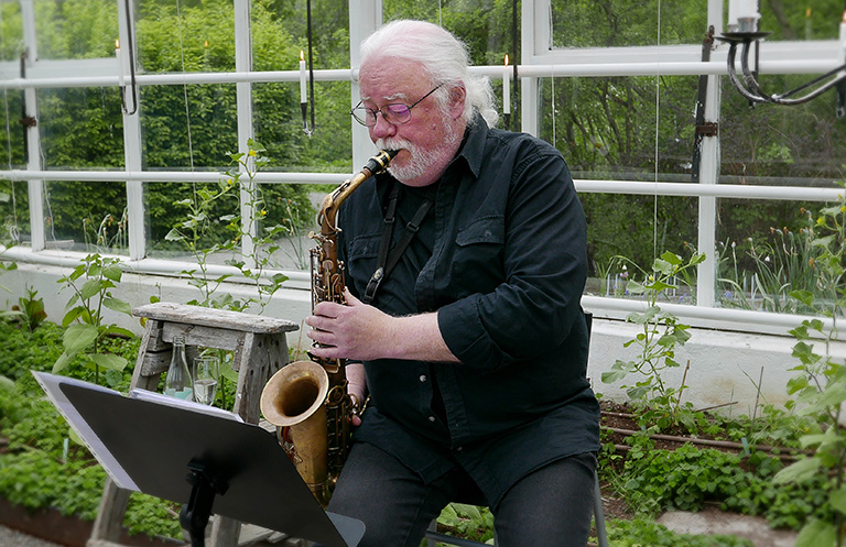 Anders Nystedt spelar saxofon på sommarmingel med tarte flambée med Galleri Andersson/Sandström på Rosendals Trädgård